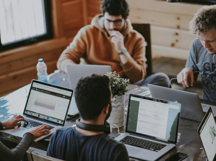 men sitting in front of their laptop computer